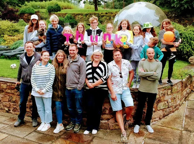 group of people with their family holding a thunk logo